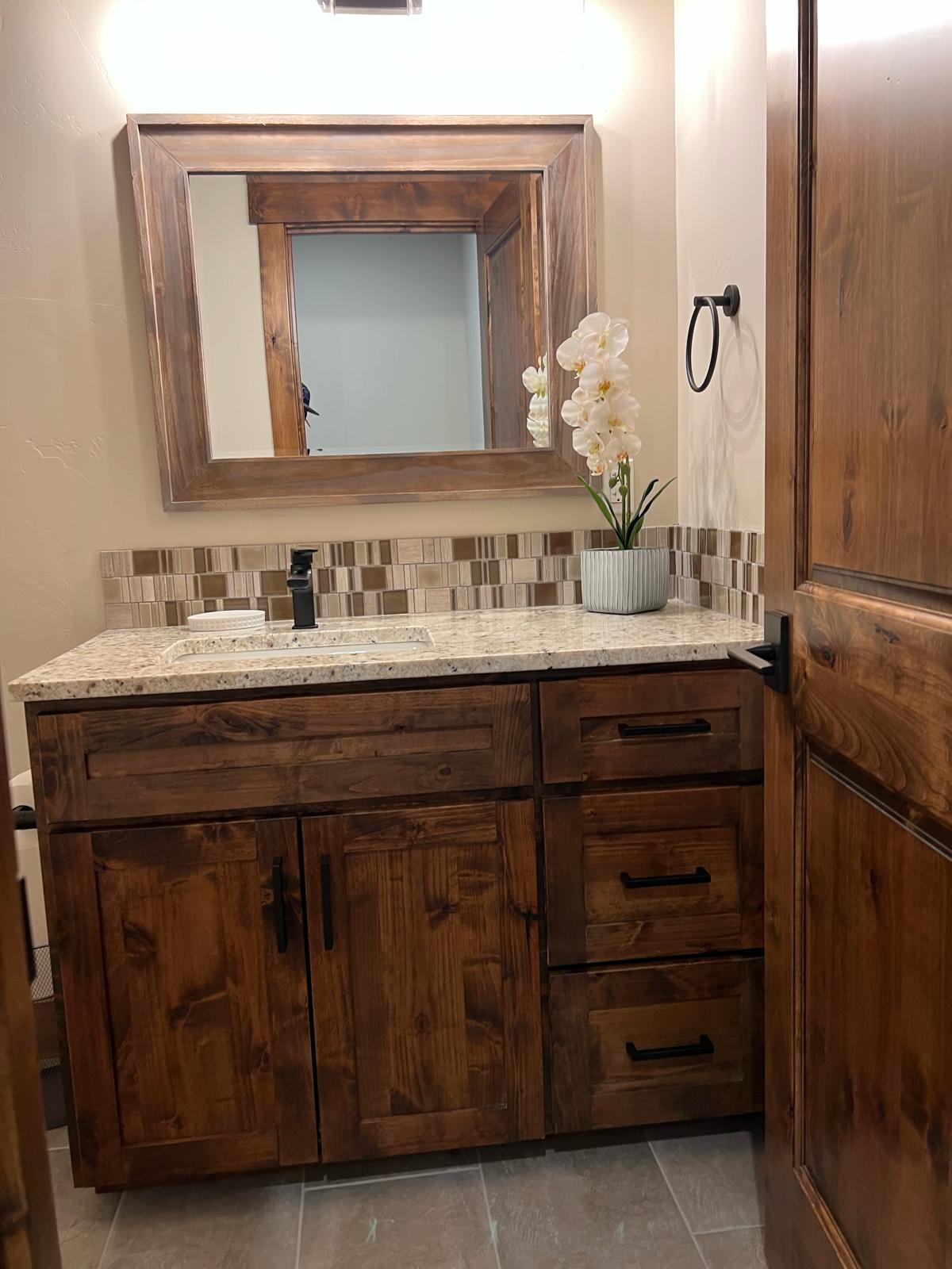 Custom powder room with rustic wood vanity and mosaic backsplash