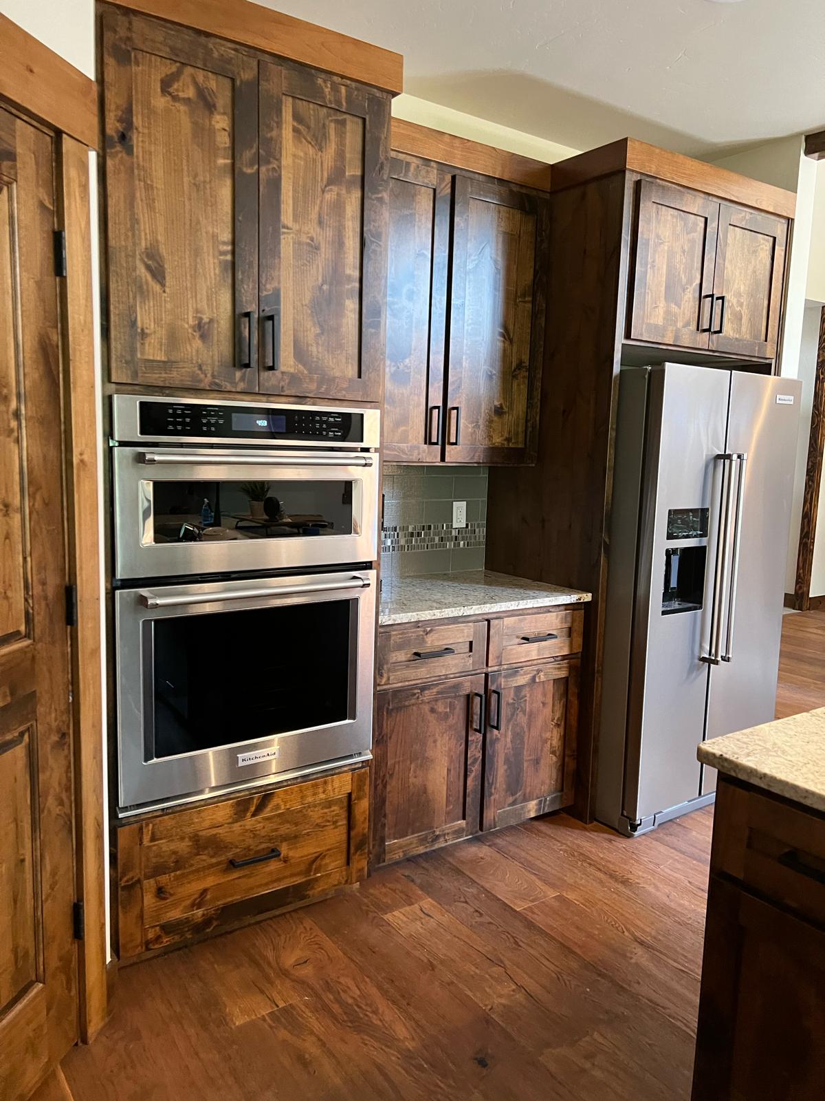 Stained alder kitchen with built-in double oven and panel-ready refrigerator