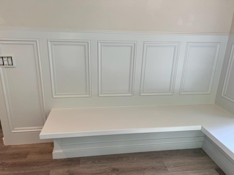 Custom wainscoted banquette base with applied molding panels
