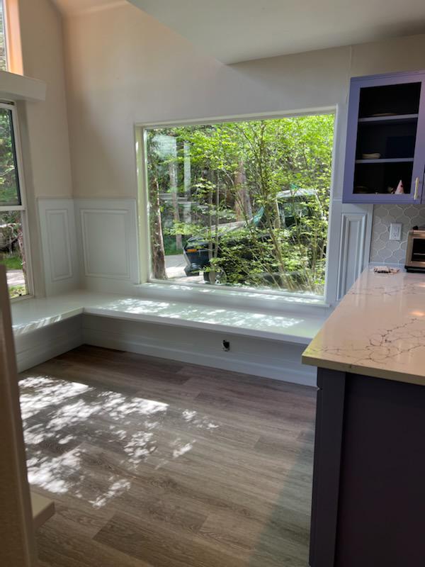 Custom built-in window seat with quartz top and wainscot panels