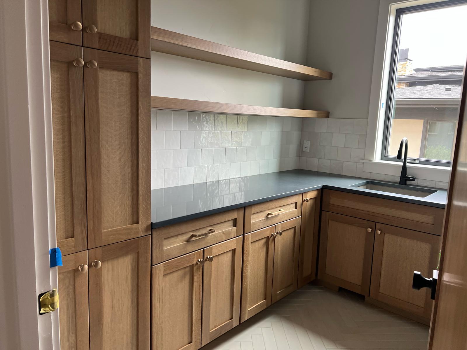 White oak butler's pantry with floating shelves and quartz countertops