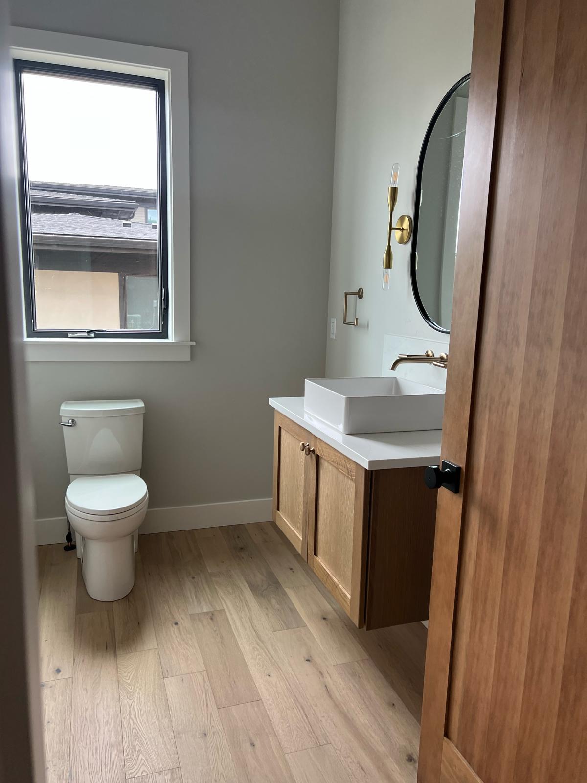 Modern powder room with floating oak vanity and vessel sink